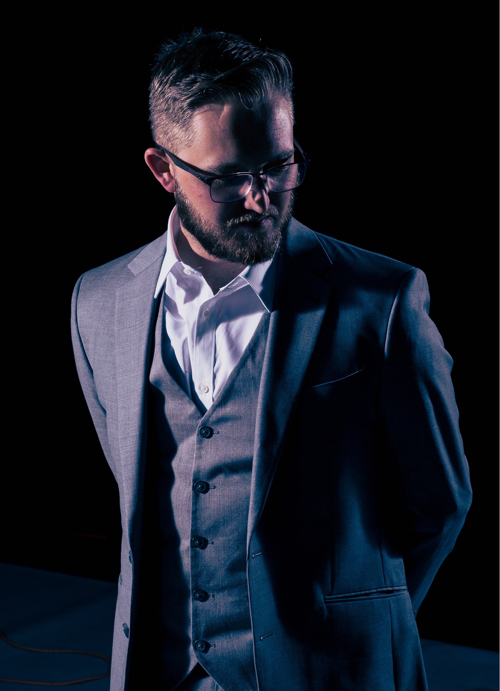 Sebastian in a suit. Dramatic lighting from the side.